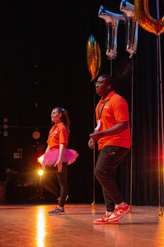 Moral leaders demonstrate their choreographed dance on stage so students can follow.