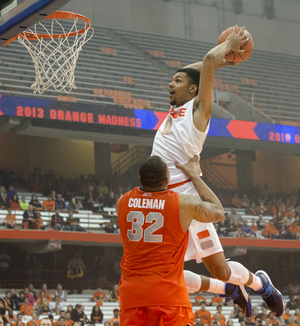 Michael Gbinje throws down in the dunk contest, with a little help from big man DaJuan Coleman. The guard won the dunk contest at Orange Madness over B.J. Johnson, Rakeem Christmas and Ron Patterson.