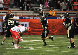 SU senior midfielder Joe Coulter crouches down in defeat as Army celebrates its 9-8 double overtime upset-win over Syracuse in the first round of the NCAA tournament Sunday.