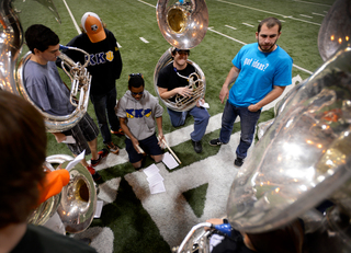 The sousaphone section gathers around Morgan Edwards, a junior music instructor, to go over some difficult song parts.