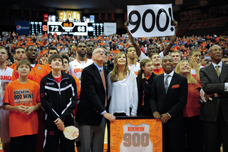 Jim Boeheim watches a video celebrating his career along with his family and his players and coaches.