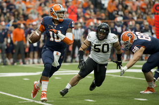 SU quarterback Terrel Hunt rolls to his right to avoid WFU nose guard Nikita Whitlock.