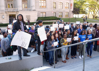 David L. Jackson, a history and secondary education sophomore, poses with students for a photo in front of the Life Sciences building during the 