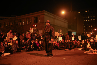 Pastor Micah Dexter speaks about his own personal experience with members of the police force in front of the Patrick J. Corbett Justice Center during Monday's 