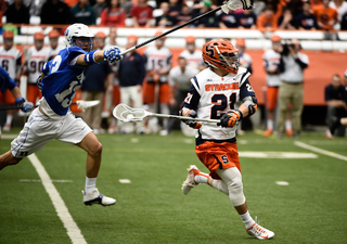 SU wing Mike Messina while Blue Devils defender Jamie Ikeda reaches out to try and knock it away.