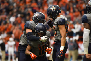 Teammates mob Sean Riley after a key punt block.